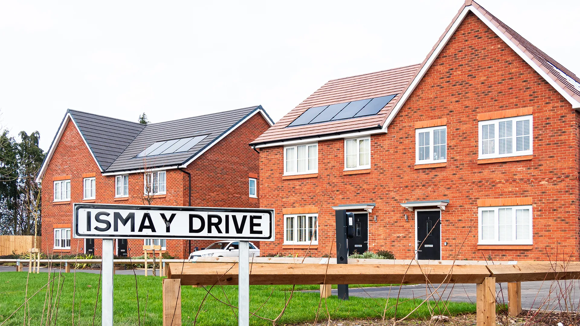 Sign for Ismay Drive with four semi-detached homes behind both with solar panels