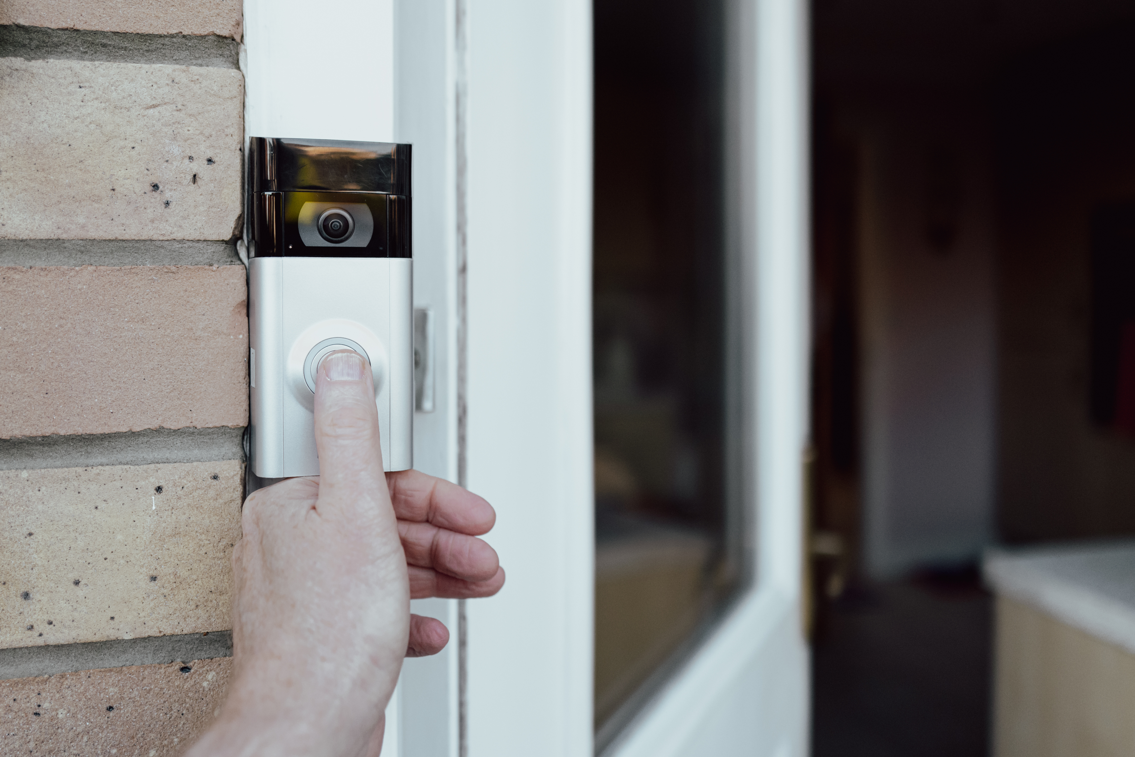 Close-up of person pressing a Ring doorbell with in-built camera
