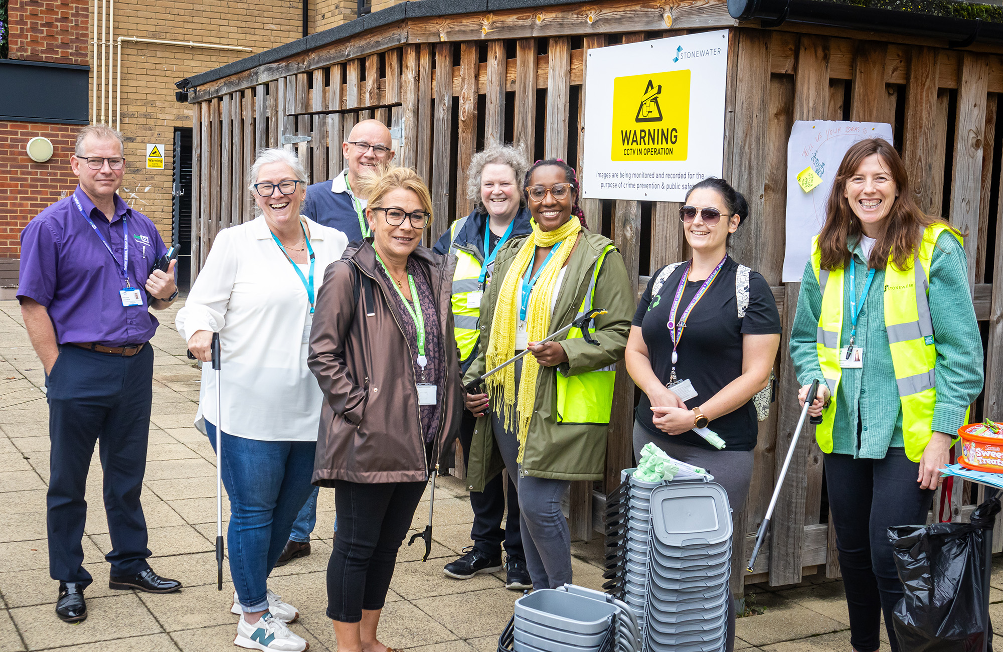 Group of people smiling whilst doing litter picking