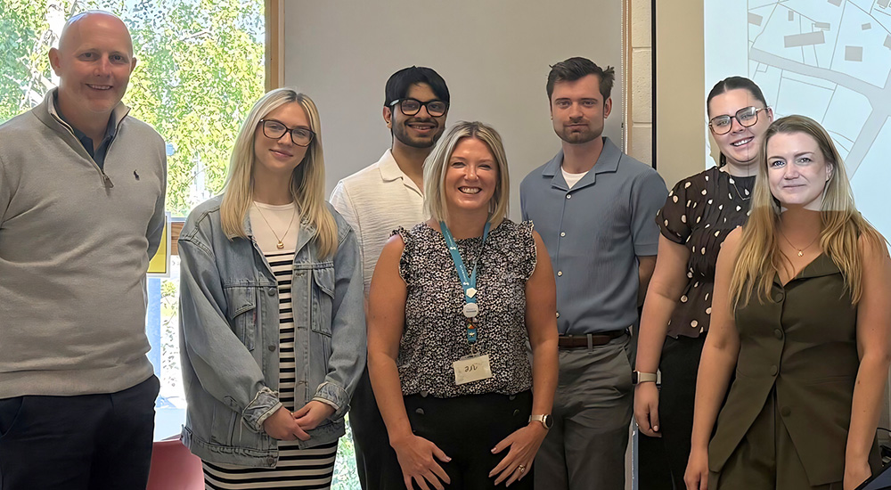 Seven people standing smiling.