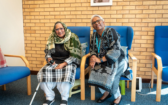 Two women sitting on chairs smiling