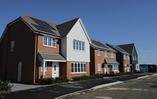 Row of 4 new build houses against blue sky