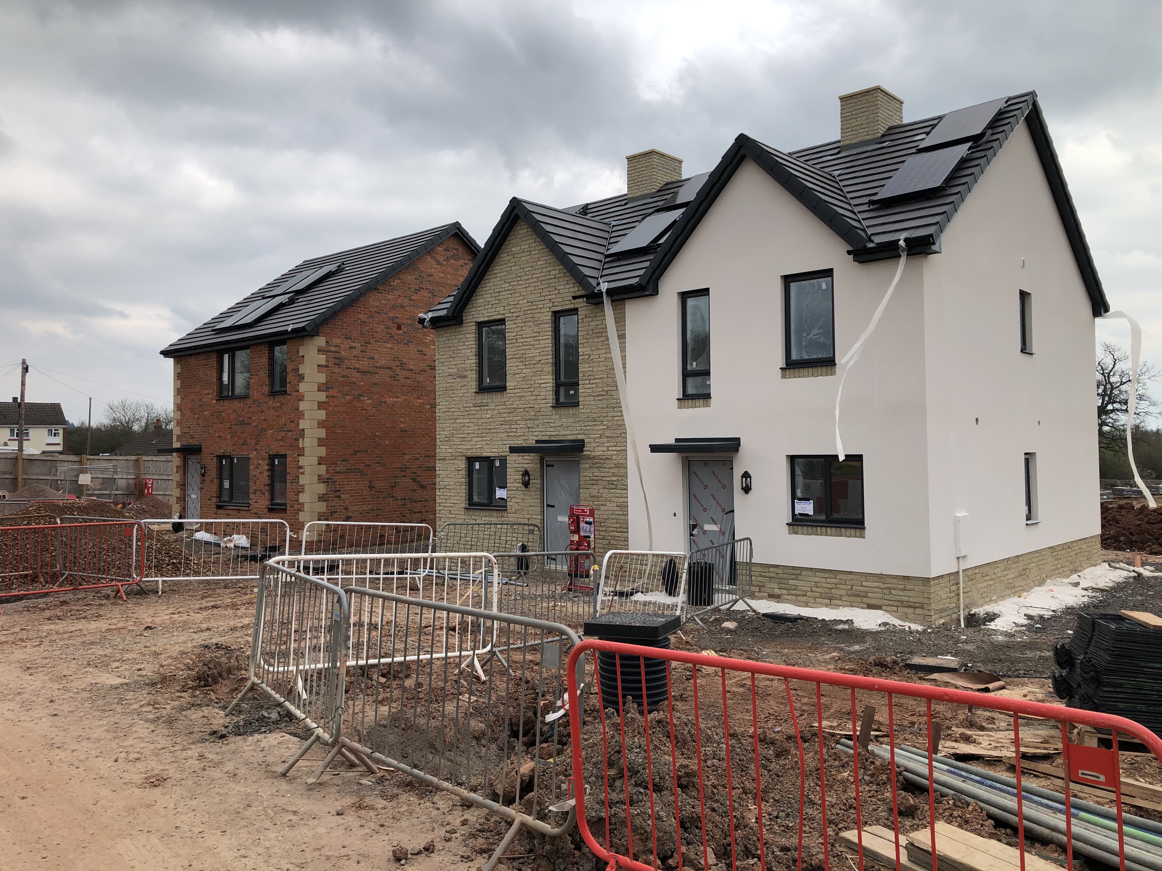 Three new-build houses near-completion on building site