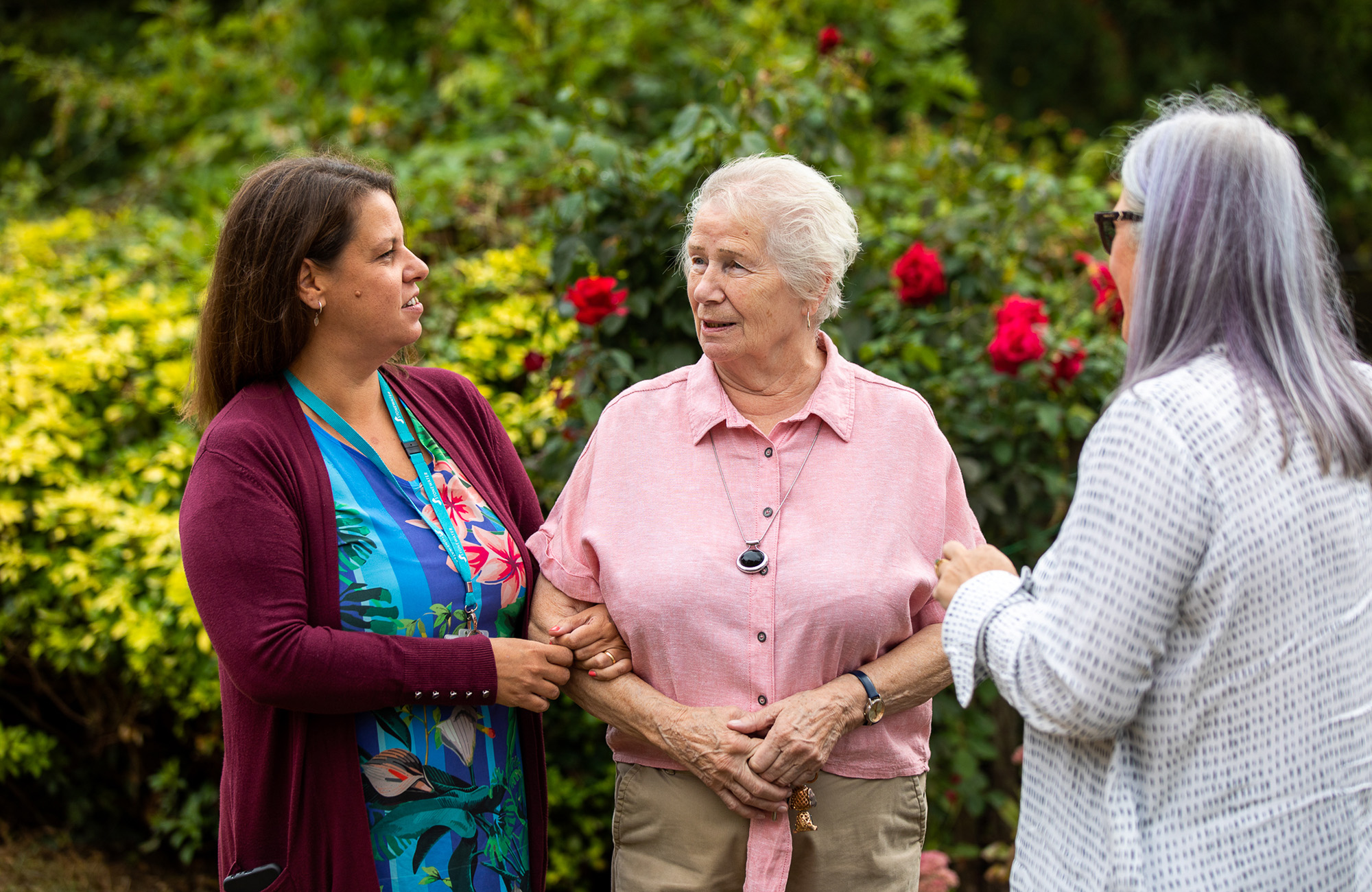 Three people talking outside