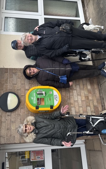 A group of four people stood around a defibrillator