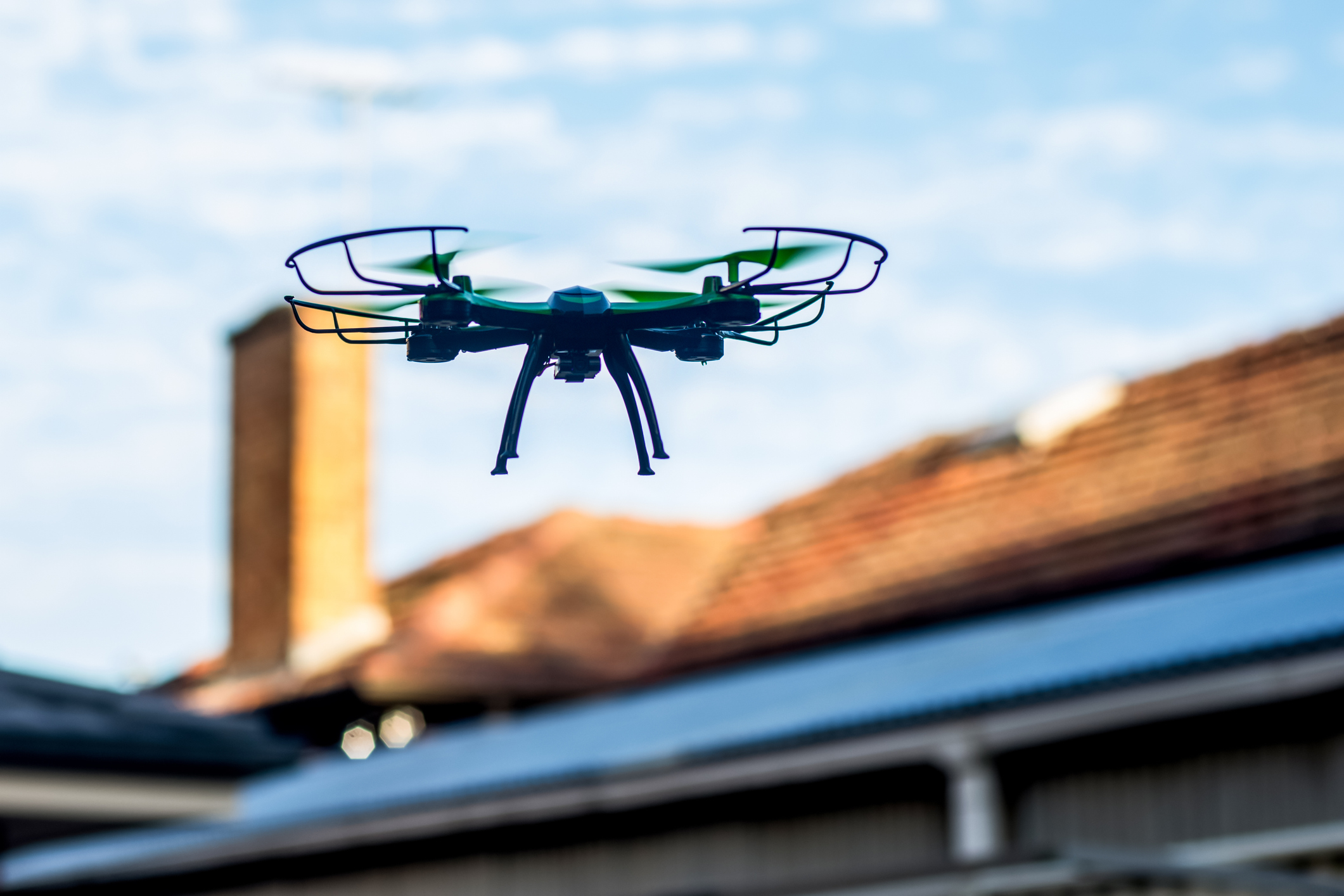 Drone flying above an out of focus rooftop