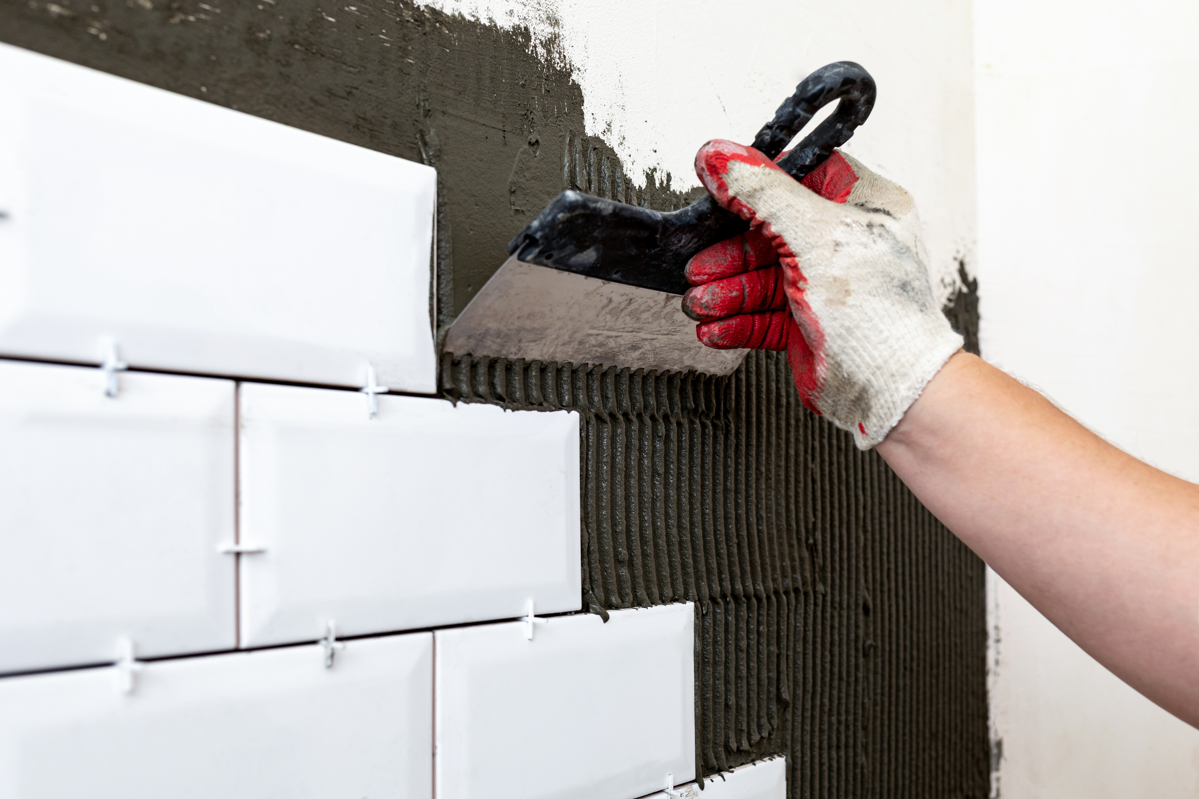 Close up of tiling a wall